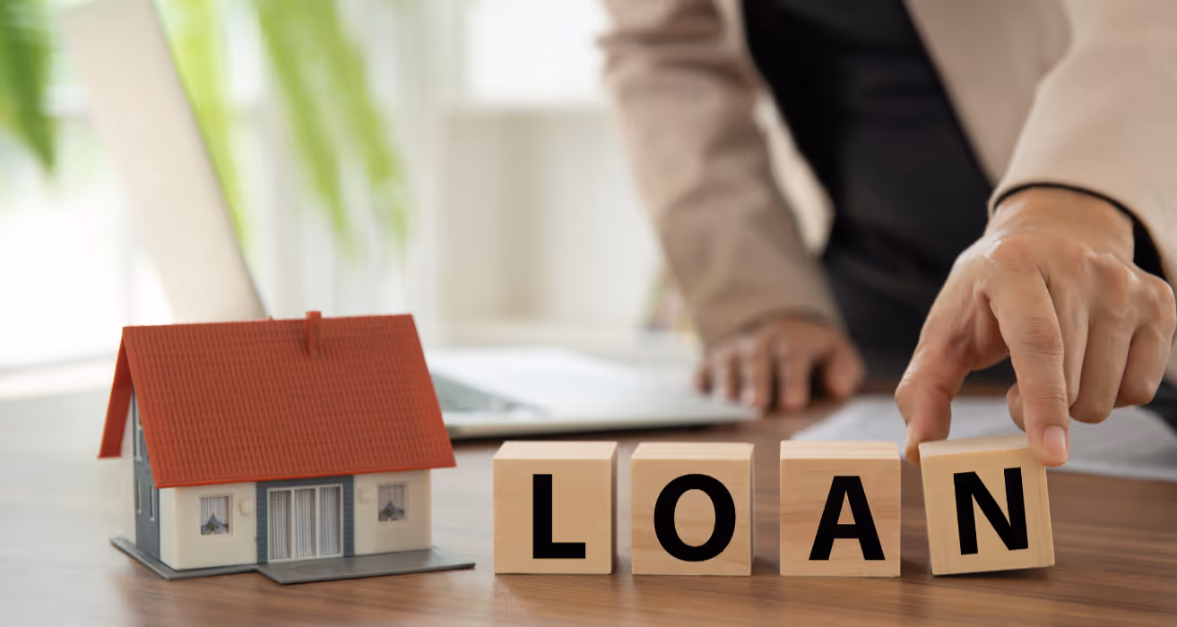 Mini house on documents with pen nearby, representing how mortgage servicing companies manage loans for homeowners.