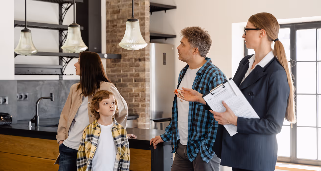 Real estate agent showing a modern condo to a young family, discussing refinance options and what to expect during the process.