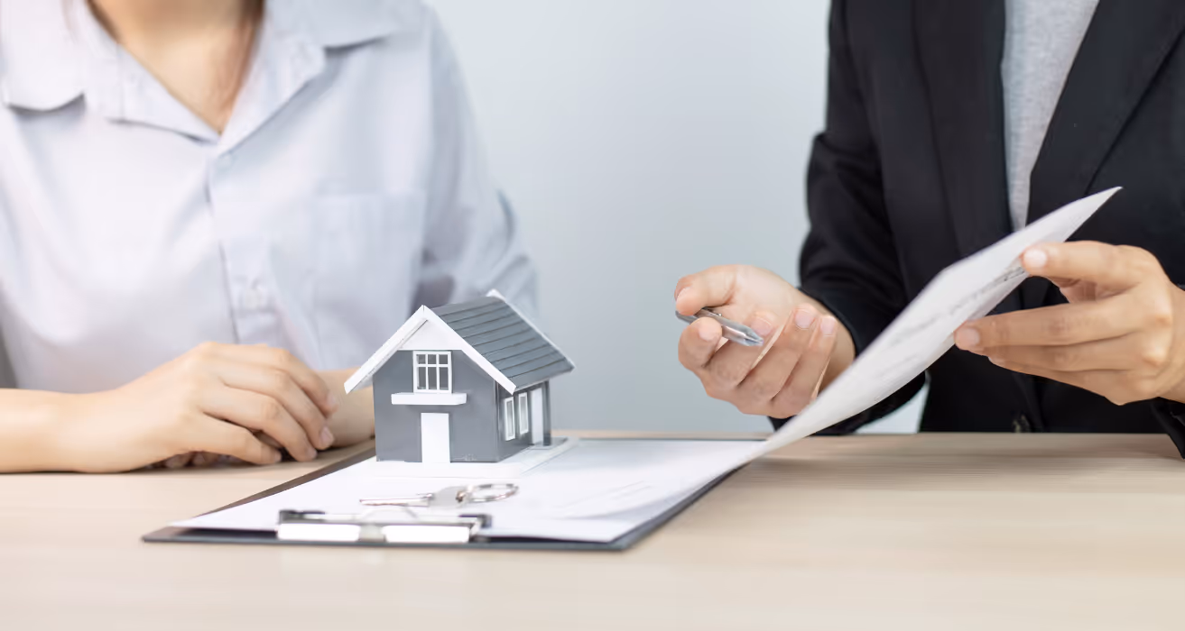 Homeowner discussing tangible net benefits of mortgage refinancing with lender, focusing on savings and loan terms