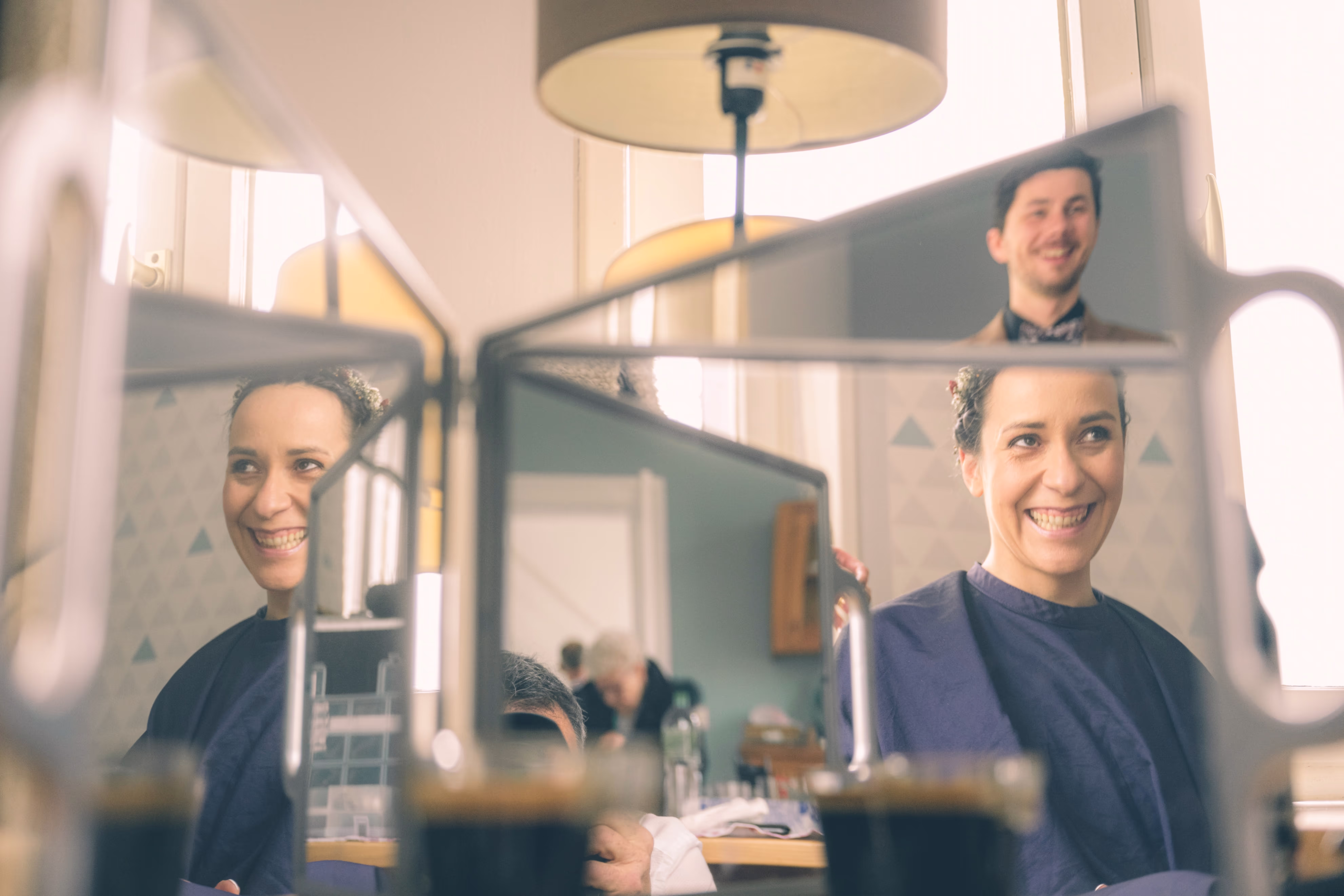Le reflet d'un et d'une mariée dans un miroir durant les préparatifs