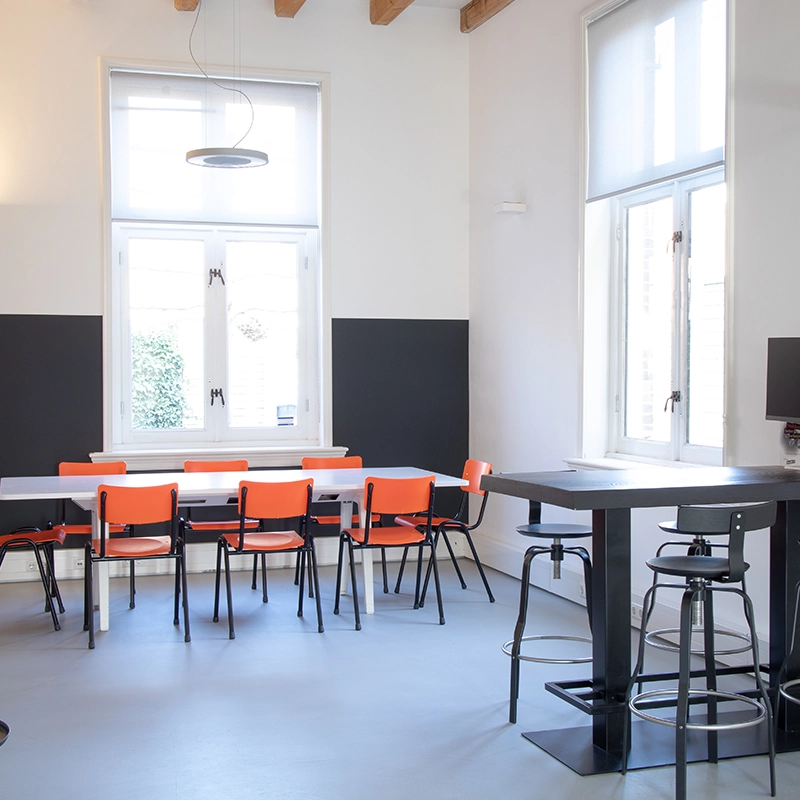 Een eettafel met stoelen en een hoge tafel met barstoelen