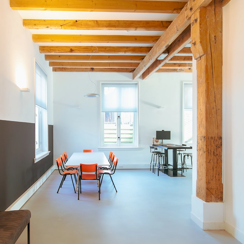 Een eettafel met stoelen en een hoge tafel met barstoelen