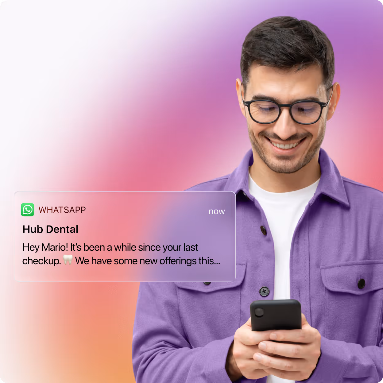 Smiling man with glasses wearing a purple shirt looking at his phone while receiving a WhatsApp message notification from Hub Dental about a checkup reminder.