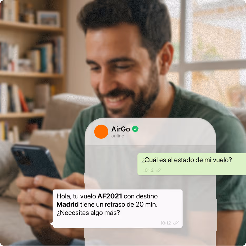 Hombre sonriendo mientras revisaba el teléfono con un chat que mostraba que el vuelo AF2021 se retrasó 20 minutos a Madrid.