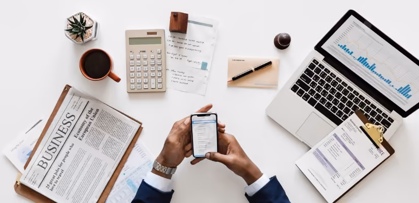 Business strategy planning with laptop, smartphone, and financial documents on desk. Perfect for digital transformation topics.