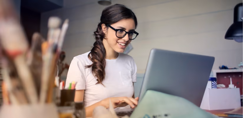 Person using laptop in creative workspace, ideal for home office or remote work articles.
