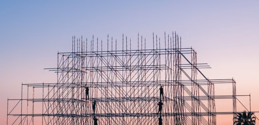 Scaffolding structure during sunset, ideal for articles on construction strategy.