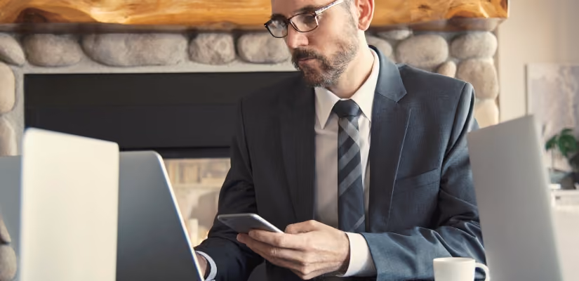 Business professional using smartphone and laptop, ideal image for WhatsApp Business API articles.