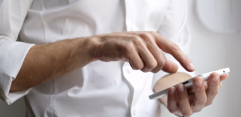 Man in white shirt using smartphone for customer service communication tools.