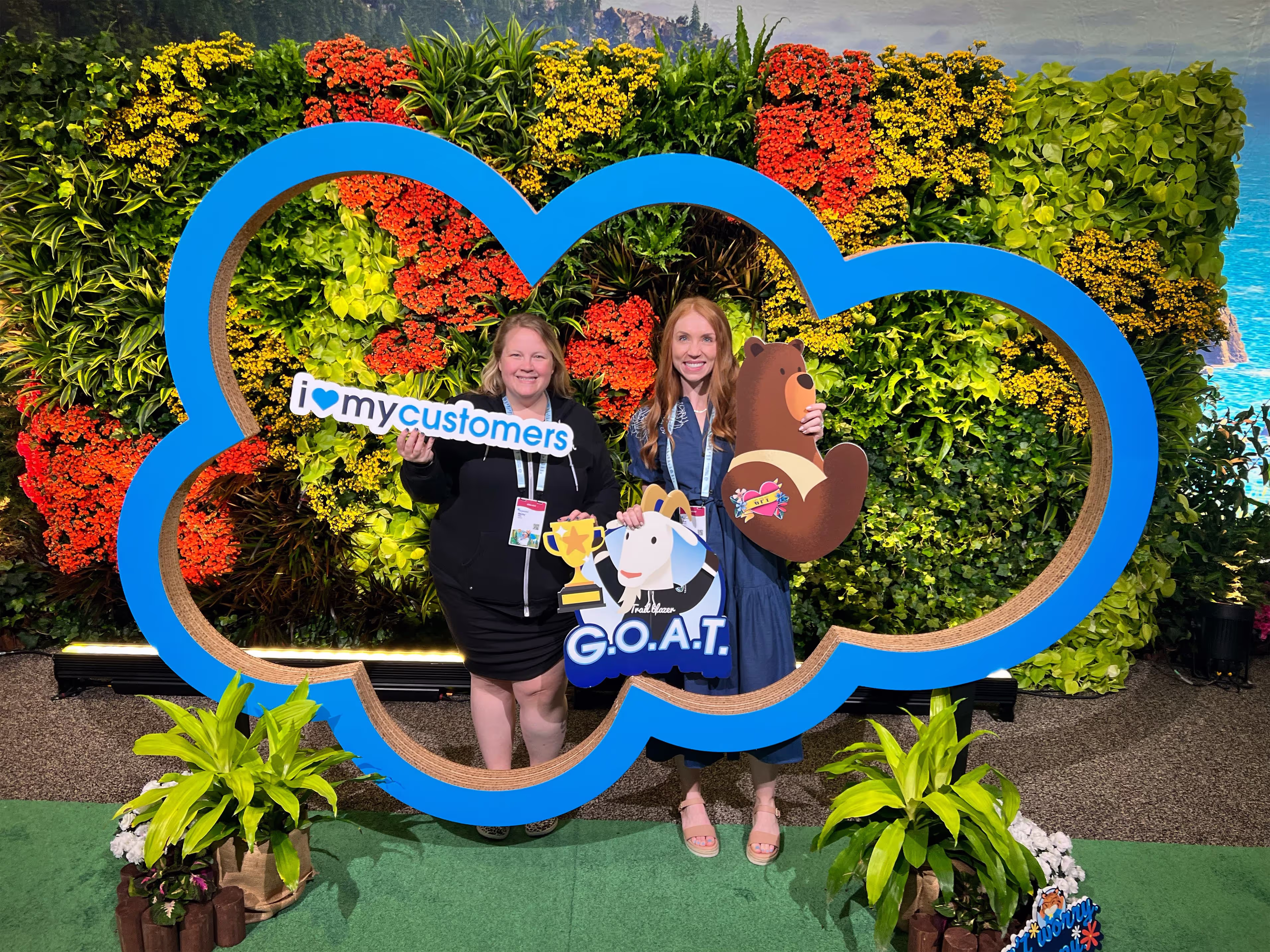 Brie Hintze and Becky Willis of Uptima at Salesforce event posing inside Salesforce cloud logo