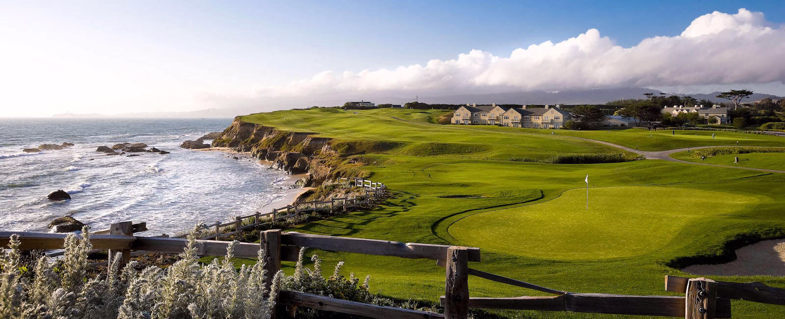 Panoramic view of Half Moon Bay golf club showcasing lush green course on seaside cliffs.