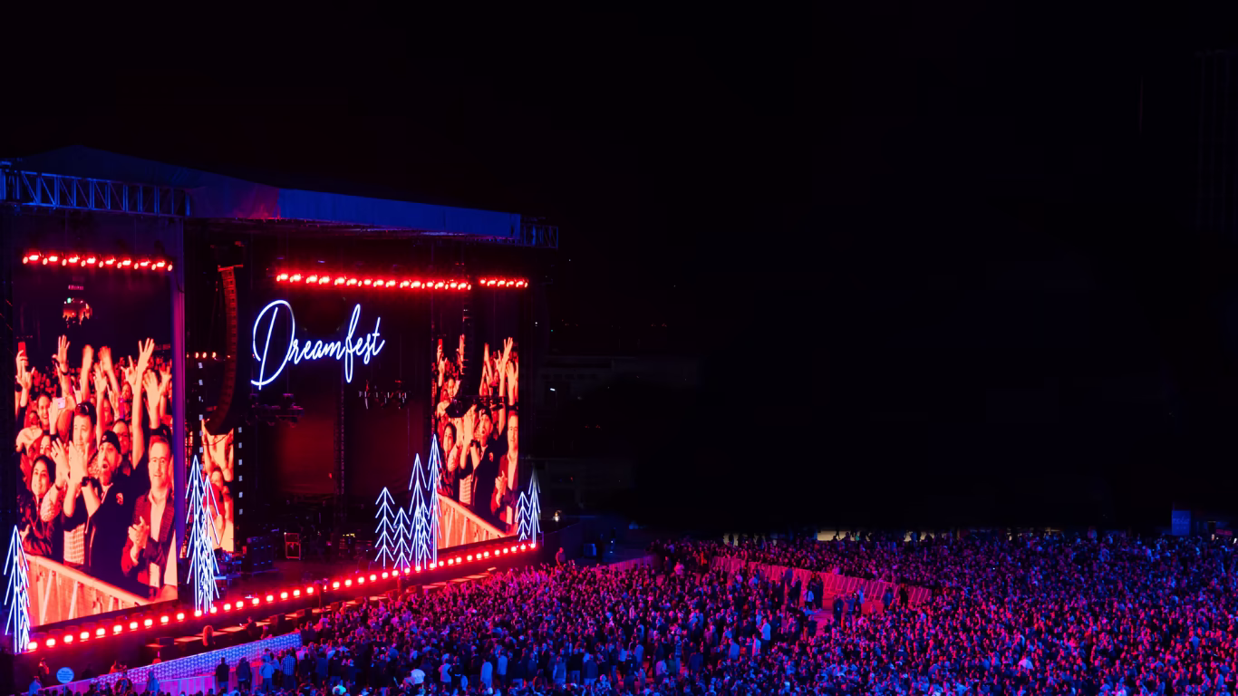 Salesforce Dreamfest outdoor concert. Huge crowd and brightly lit stage surrounded by black sky.