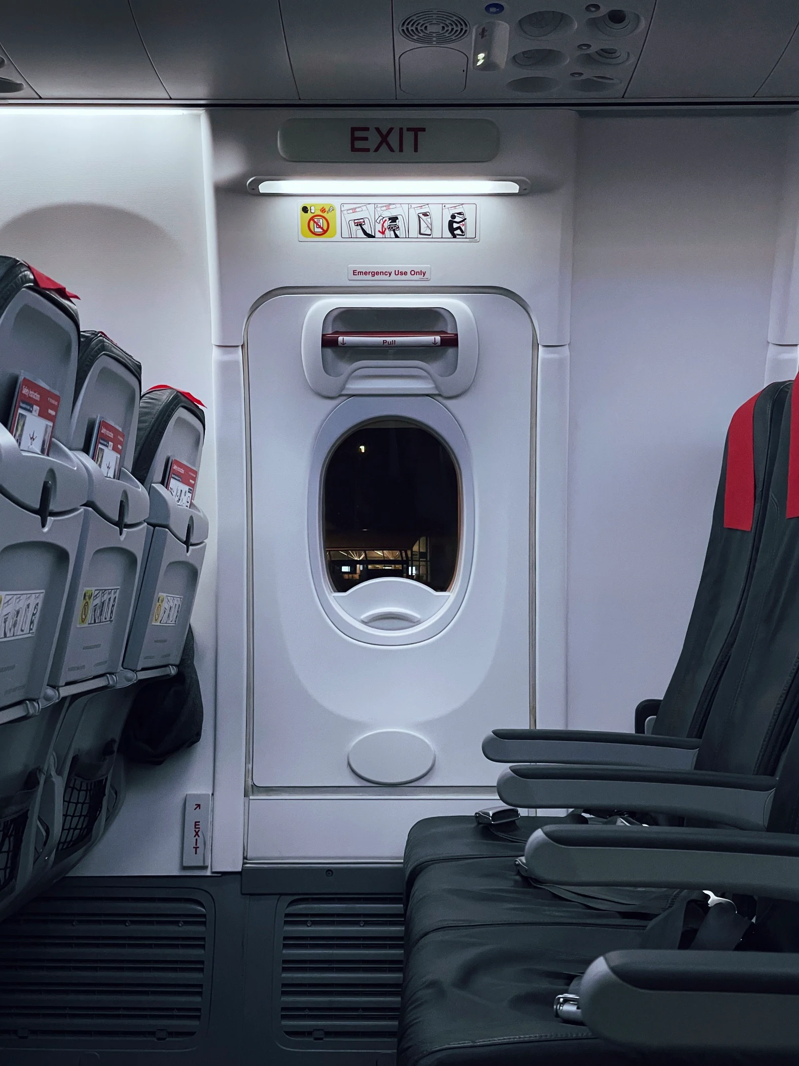 A shot of an interior of an aeroplane's emergency aisle with extra leg room.