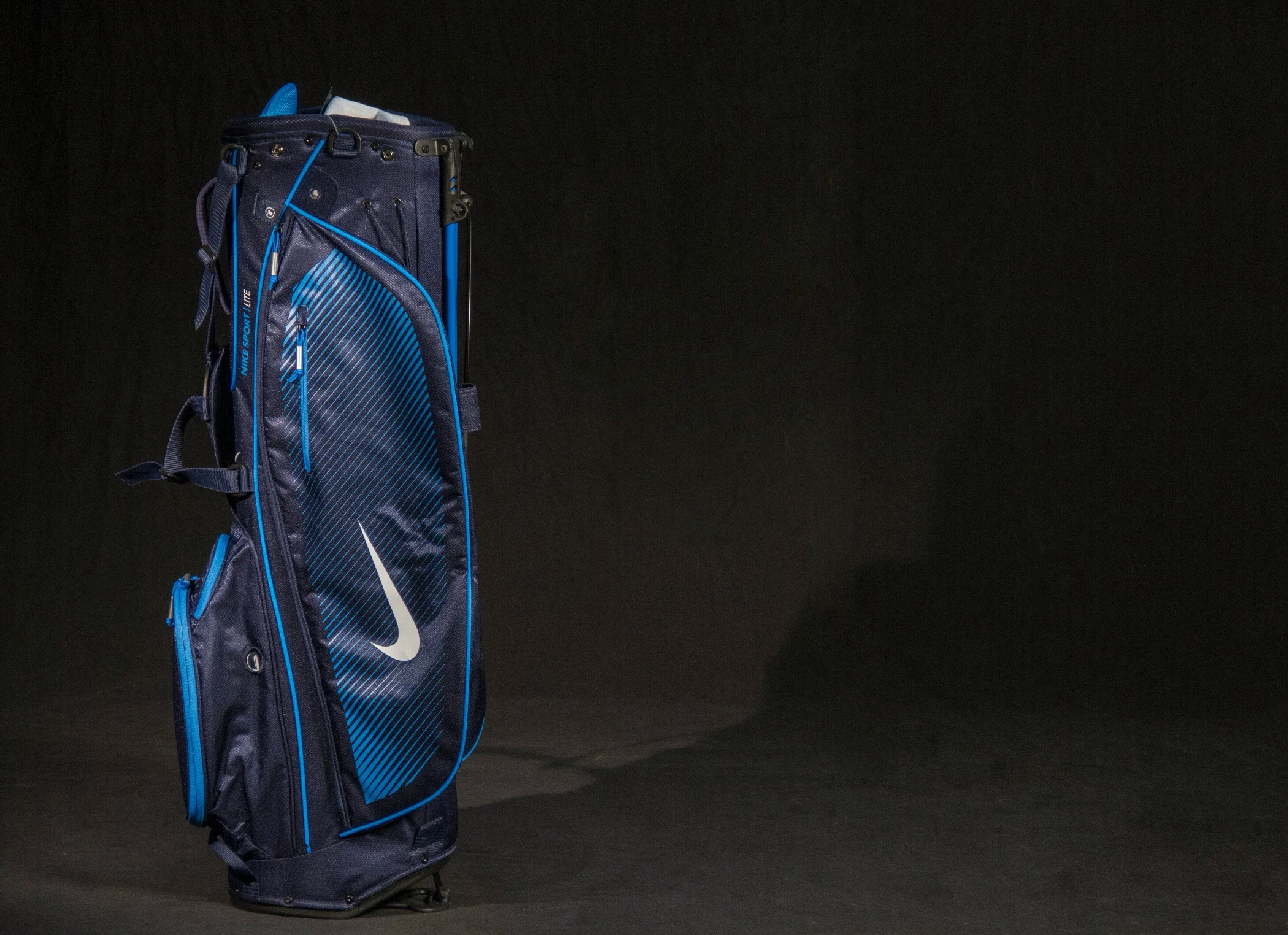 A blue golf bag against a black background.
