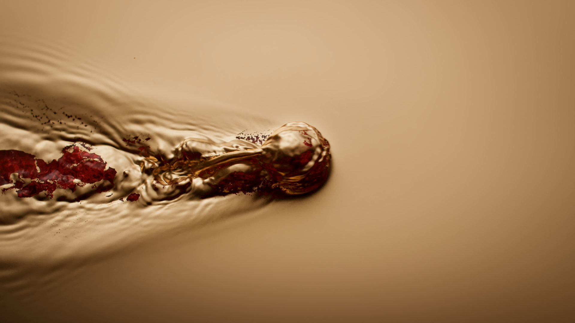 A still off lucie conrad's concept film "red", produced by mat. studio, showcasing a golden and red liquid, with a ball moving and disrupting the liquid