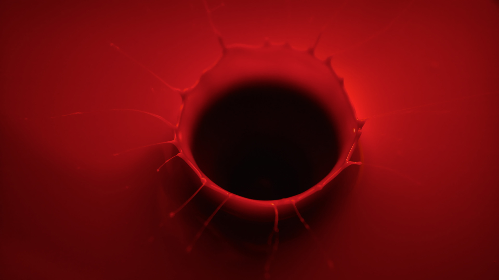 A still off lucie conrad's concept film "red", produced by mat. studio, showcasing the aftermath of a drop in a red liquid, almost wax-like