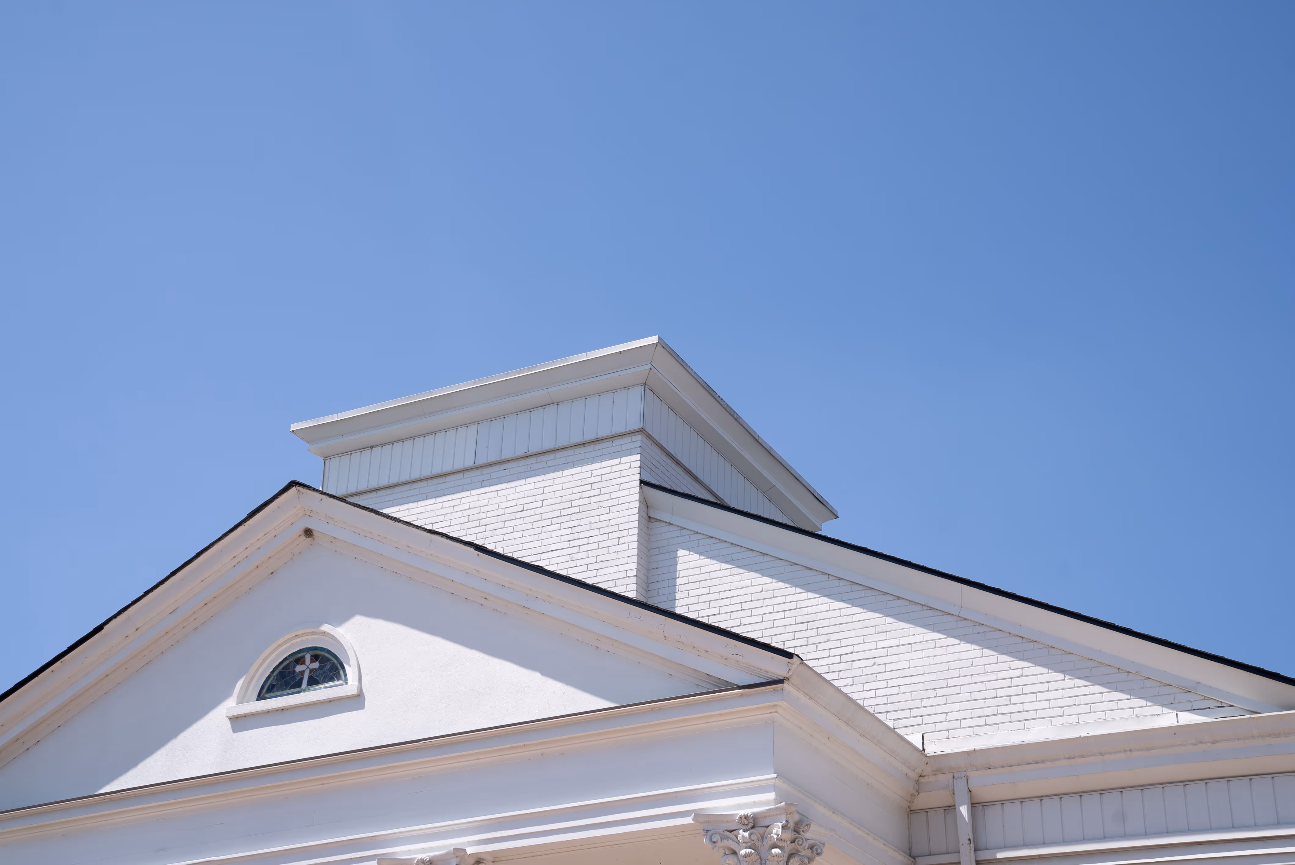 Top of a building with a blue sky in the background.