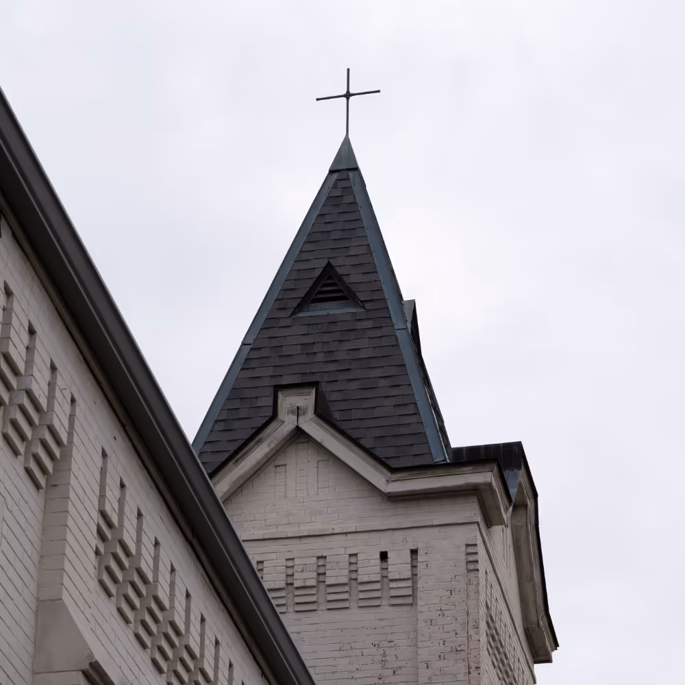 Roof and steeple with cross at the top.