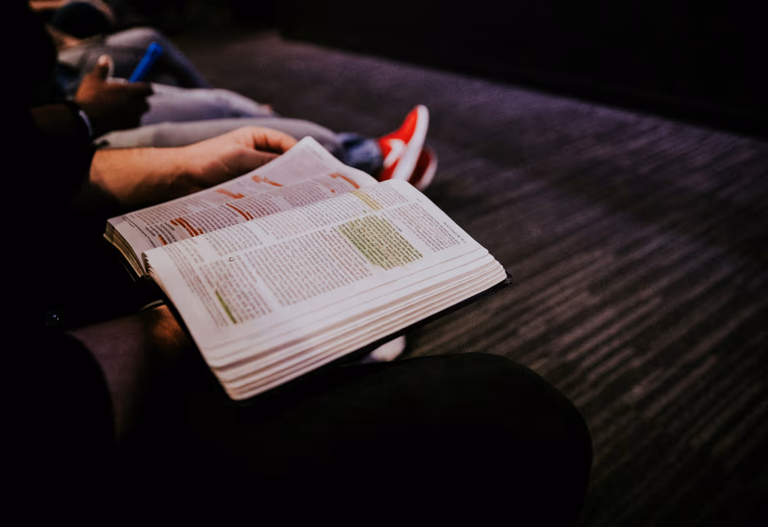 Open bible with highlighted verses on someones lap.