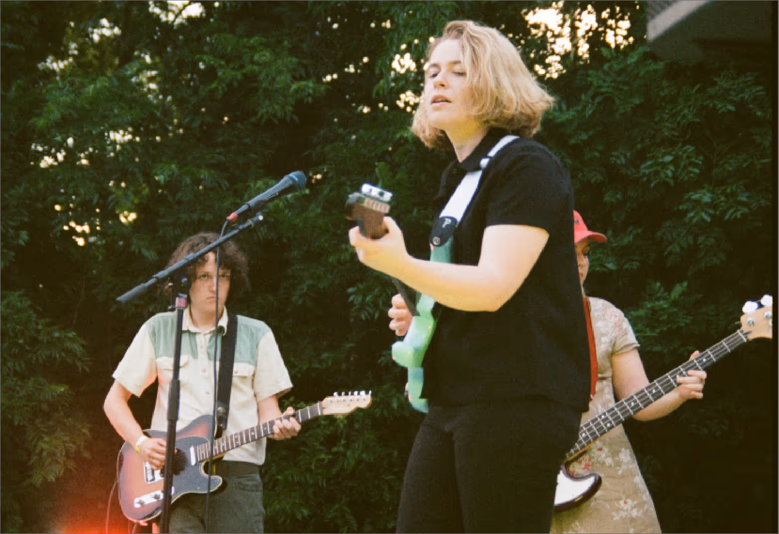 Young adults playing in a band outdoors.