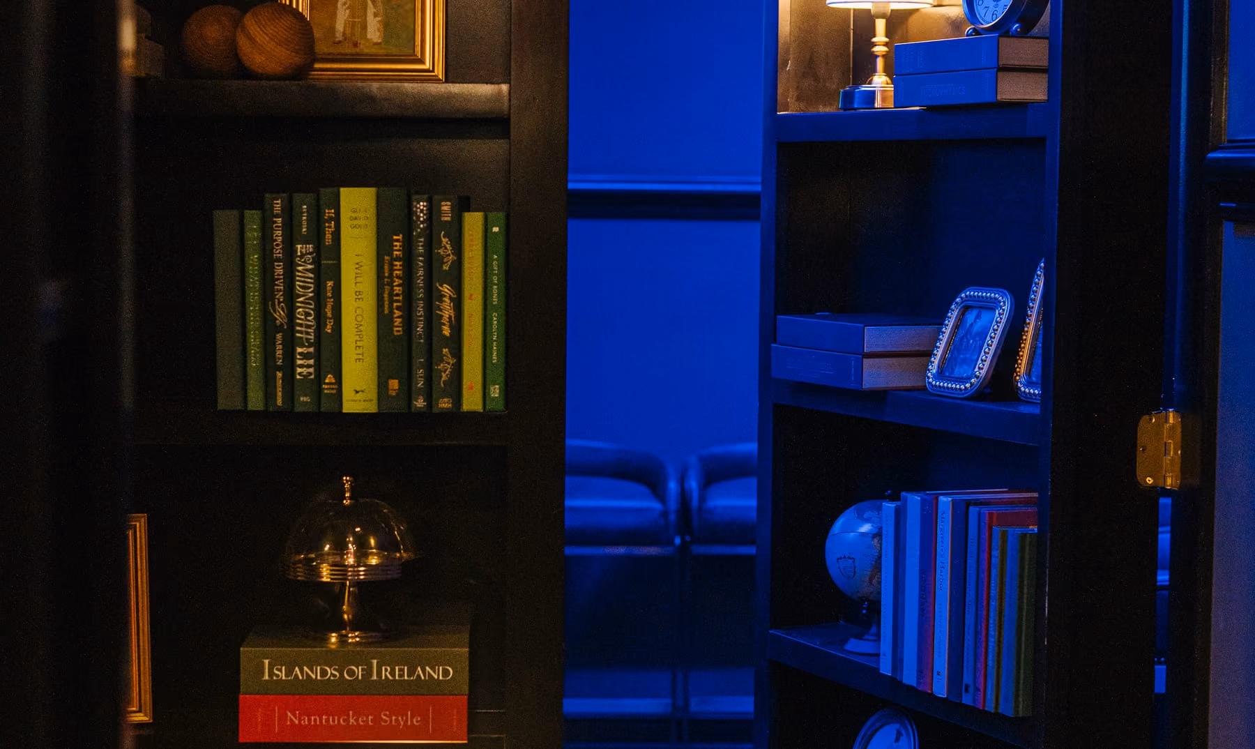 Hidden bookcase door lit in blue leading to Stewart's private karaoke room