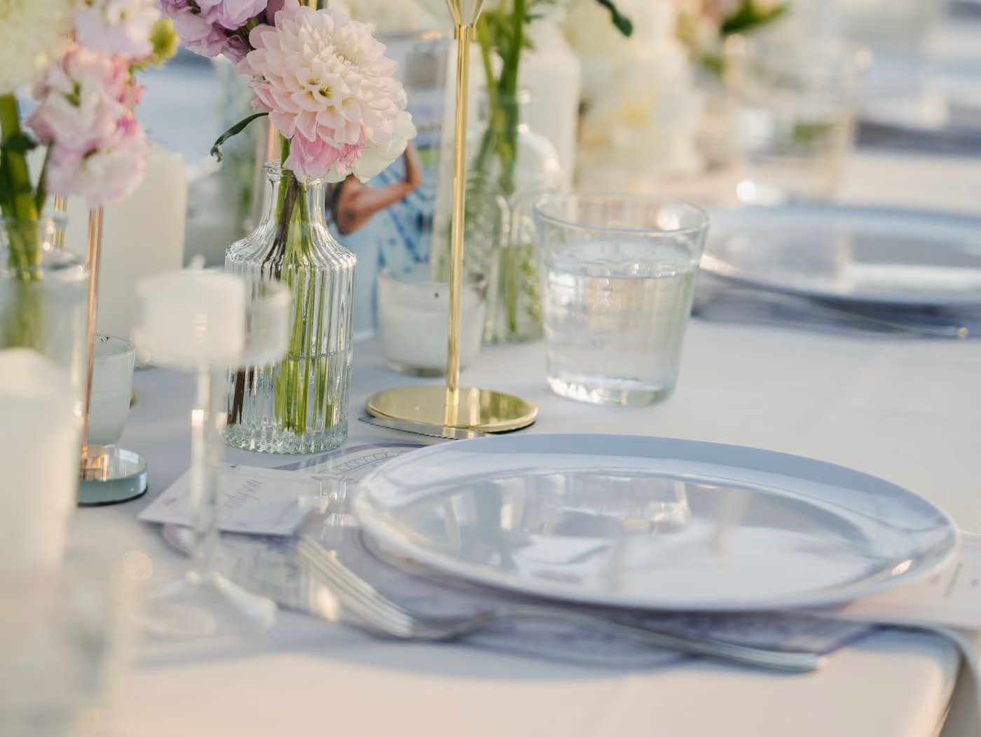 Long wedding table set with tapers, pale florals and gold accents