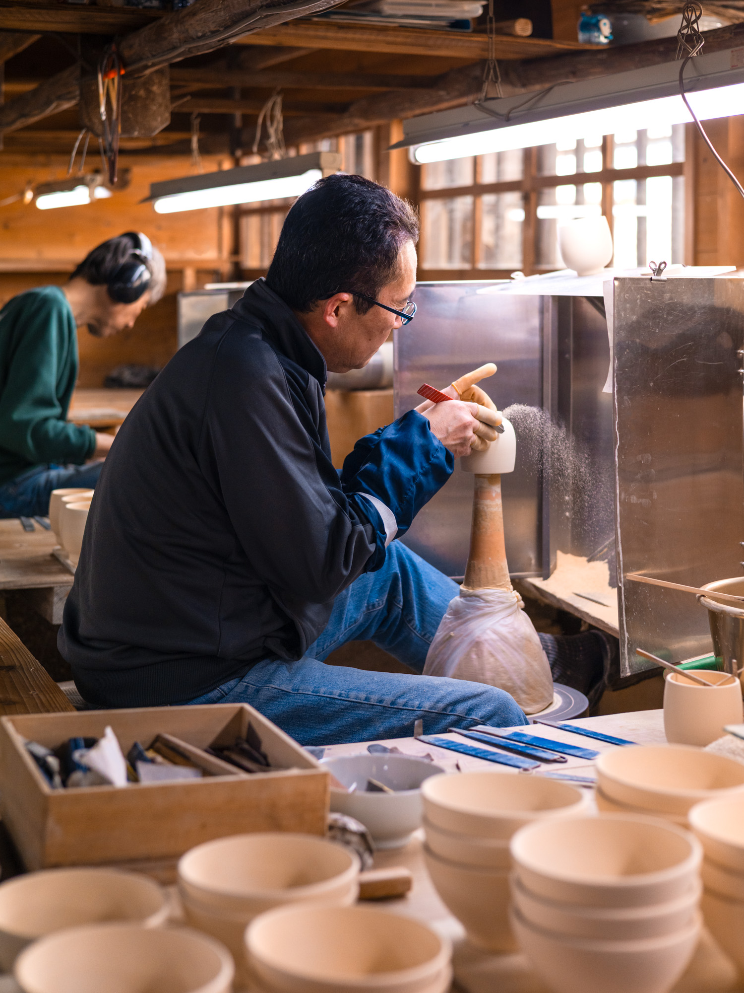 Tucked into the wooded hills of Saga Prefecture, far from Japan’s more trodden tourist trails, lies a kiln that has quietly upheld the art of Japanese porcelain for over 150 years. Genemon Kiln, located just outside Arita, offers more than just ceramics. It’s a living archive, a place where brushstroke, glaze, and fire still follow centuries-old rhythms, and where history isn’t behind glass, but carried in the fingertips of working craftsmen.