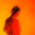 Silhouette of a person with blurred red and orange background creating an abstract effect.