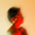 Blurry silhouette of a person with a red light cast on their face and upper body against a light background.