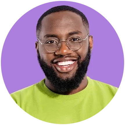 Portrait of a smiling man with short hair and a beard wearing glasses and a green shirt.