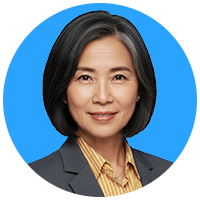 Portrait of a happy woman with black hair styled into a bob, wearing a dark grey blazer and a gold shirt with thin, white stripes.