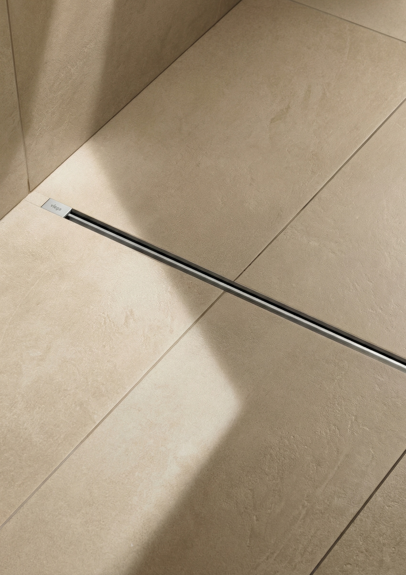 Beige ceramic tiles with black linear drain installed between floor panels