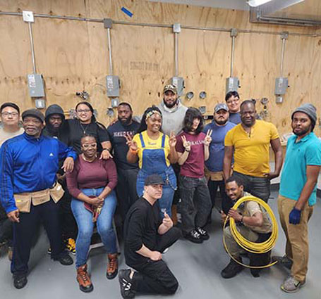Thumbnail of Shannon Wright surrounded by her construction students in the shop at Apex Technical School