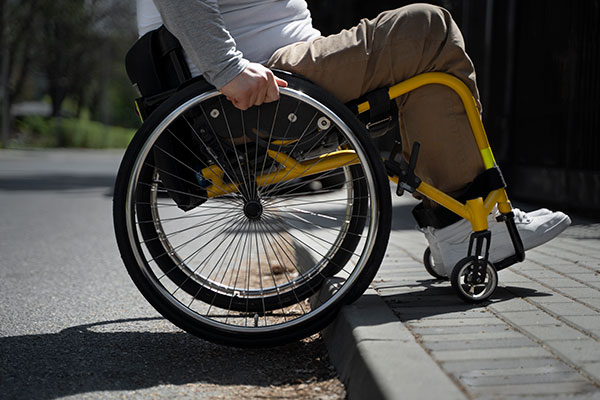 A man uses a wheelchair to cross a ramp and enter his home
