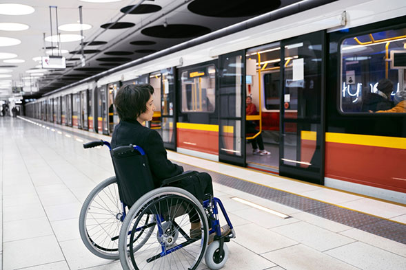 A man uses a wheelchair-accessible elevator to enter his apartment thanks to ADA building requirements