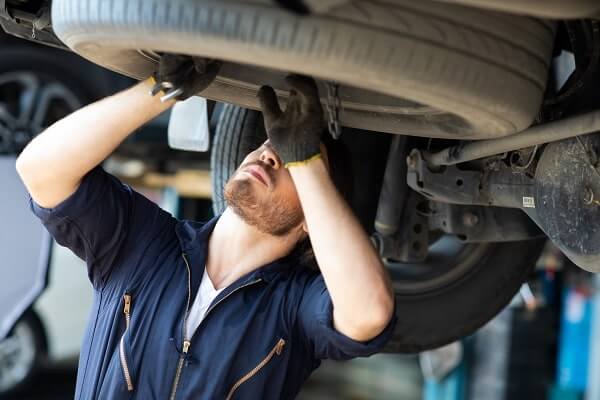 A student reaches up to change a tire