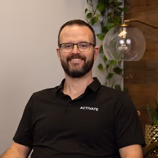 Professional headshot of Evan, Activate team member, in business attire
