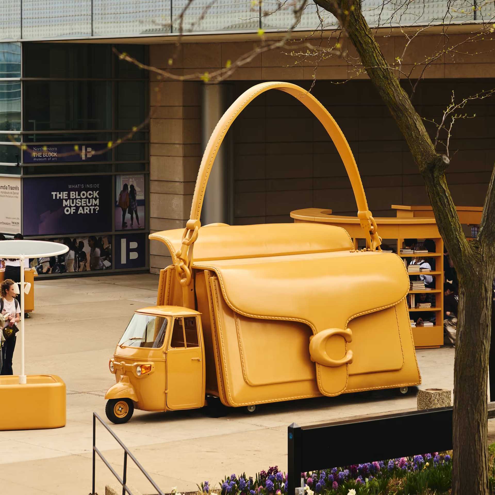 Coach Tabby bag-shaped vehicle on a college campus during the Coach mobile tour