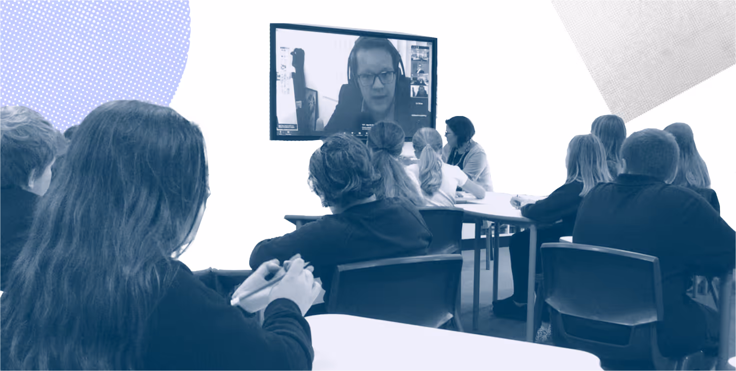 Learners in a classroom at Cowbridge Comprehensive school speaking with MS Joel James, seen on projector screen, during an online dialogue session.