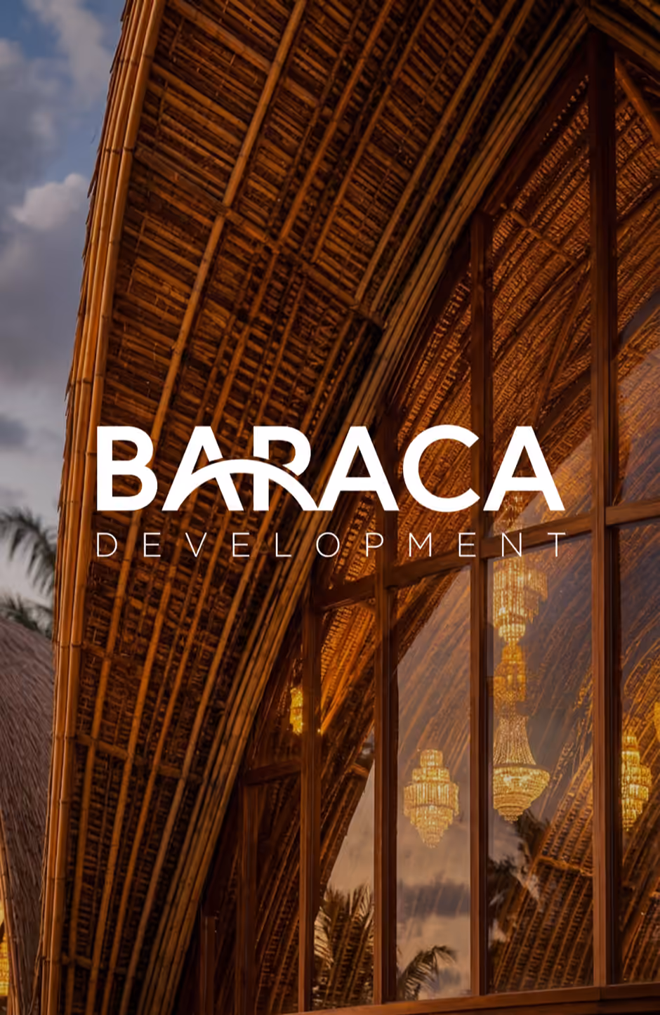 Bamboo structure with warm lights and chandeliers reflected in glass panels.