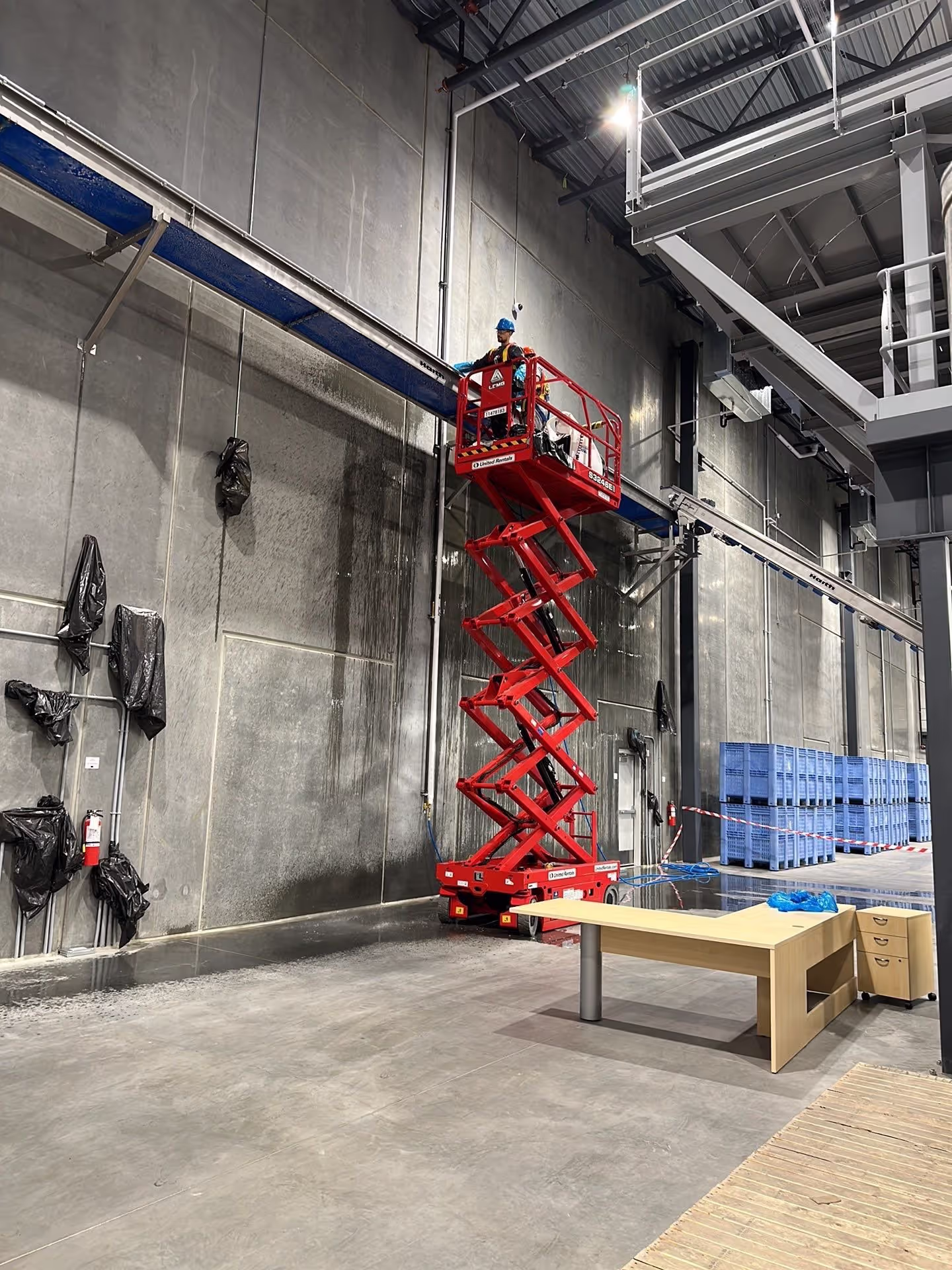 Industrial overhead cleaning service using a lift.
