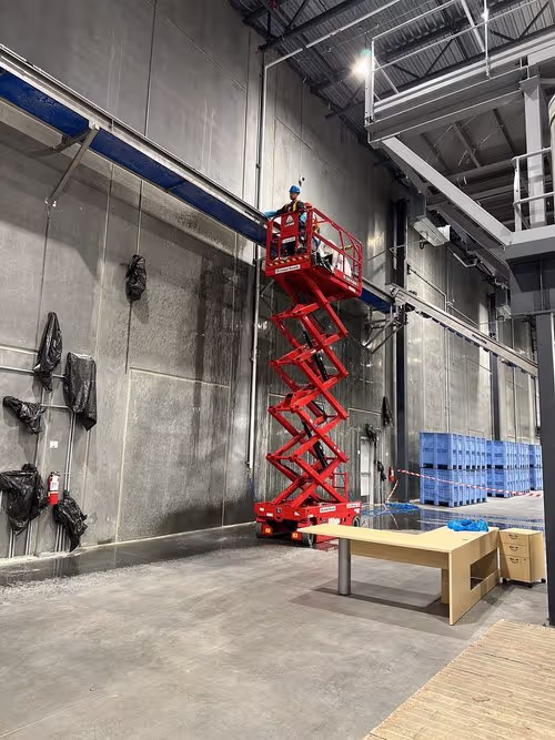 Industrial overhead cleaning service using a lift.