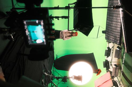 behind the scene shot of production on a green screen studio