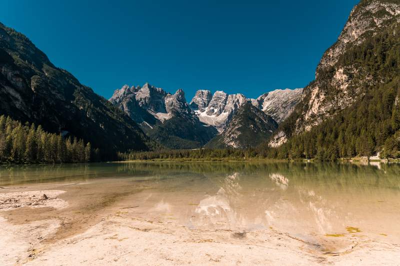 Lago di Braies with turquoise waters surrounded by Dolomite mountains