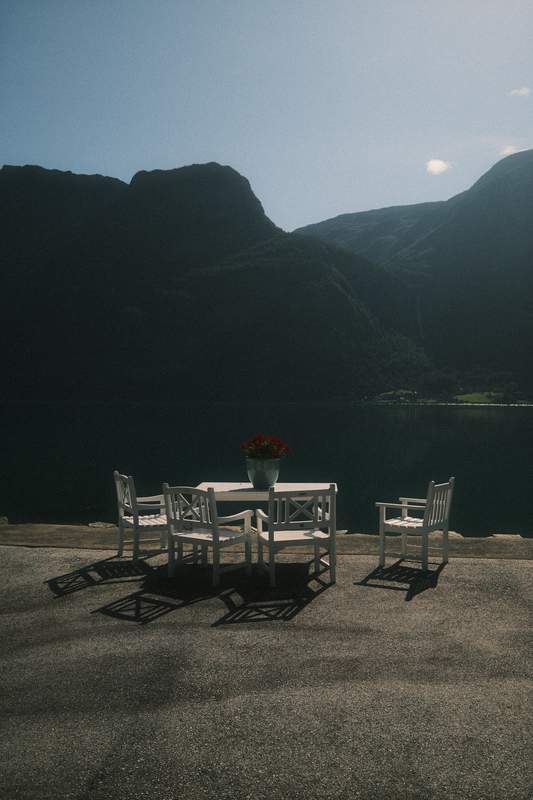 A table with chair near a norvegian fjord.