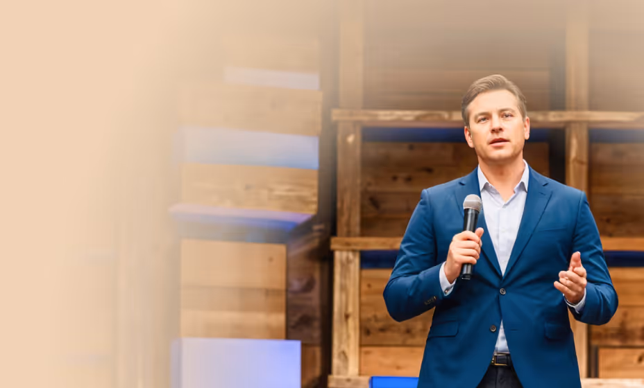 Speaker on stage delivering a talk about faith and theology.