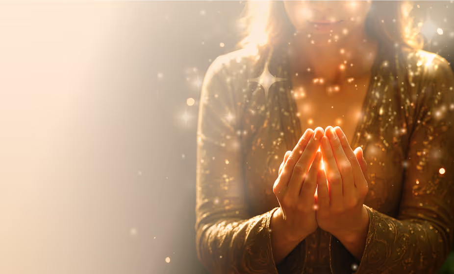 Woman cupping glowing light in her hands in prayer — symbolic of personal prayer, hope and faith.