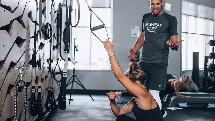 A woman is doing a pushup on a gym floor.