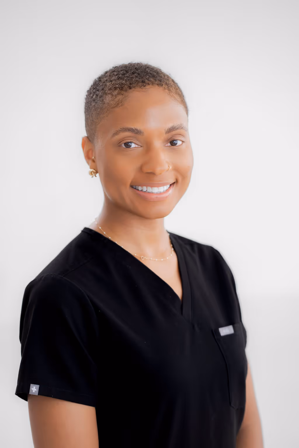 Foto de la Dra. Taylor, médica y especialista principal del Centro de Mareos de Texas, sonriendo con confianza y con los brazos cruzados.