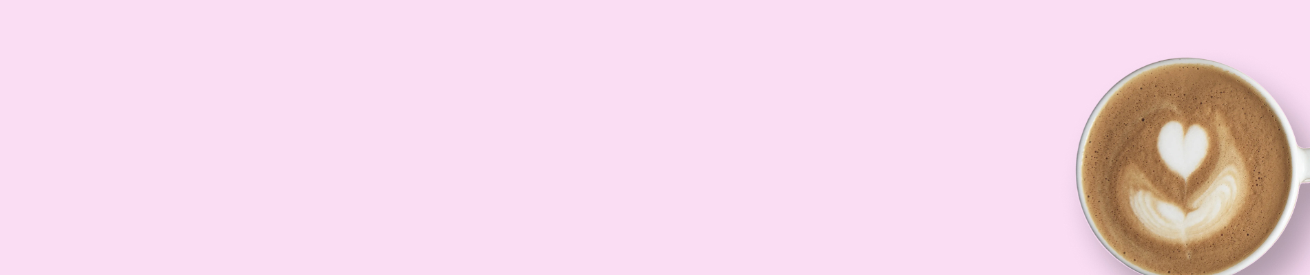 Eine Tasse Cappuccino mit Milchschaum in Herzform auf rosa Hintergrund.